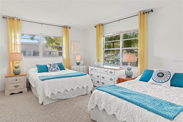 bedroom featuring light colored carpet and a textured ceiling