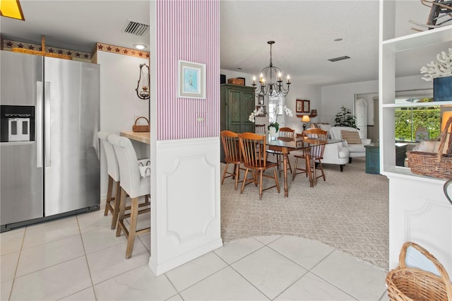 kitchen with hanging light fixtures, a chandelier, stainless steel fridge with ice dispenser, and light tile patterned flooring