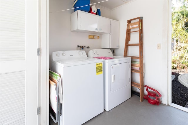 clothes washing area featuring plenty of natural light, cabinets, and washing machine and dryer