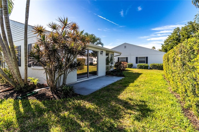 back of property featuring a lawn and a patio