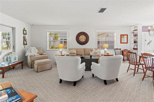 carpeted living room featuring visible vents and a textured ceiling