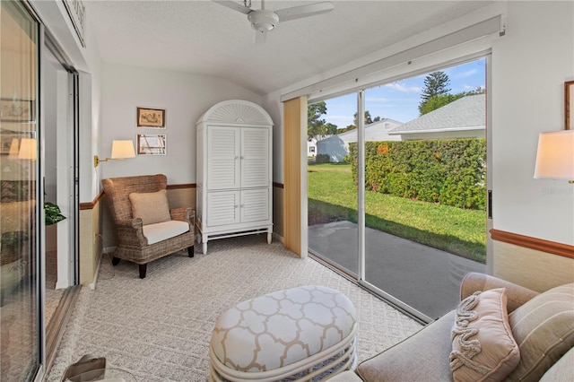 sitting room with light colored carpet, a textured ceiling, a ceiling fan, and vaulted ceiling