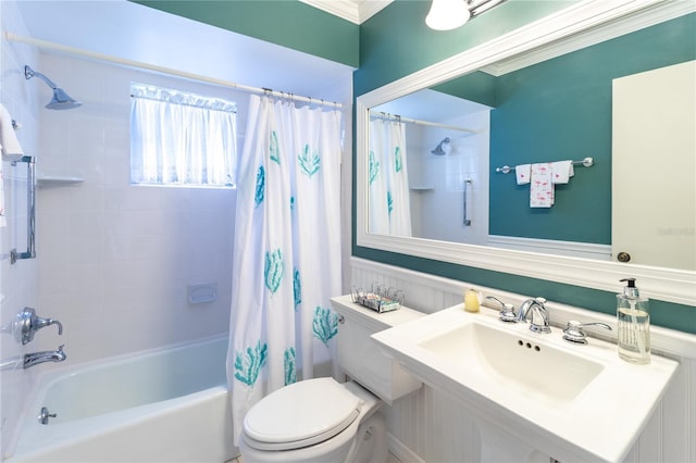 bathroom featuring a sink, toilet, and shower / bathtub combination with curtain