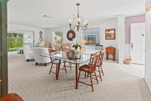 carpeted dining space featuring tile patterned floors, visible vents, a textured ceiling, and an inviting chandelier