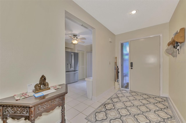 foyer with light tile patterned floors and ceiling fan