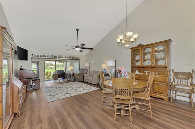 dining area with ceiling fan with notable chandelier, high vaulted ceiling, and hardwood / wood-style flooring