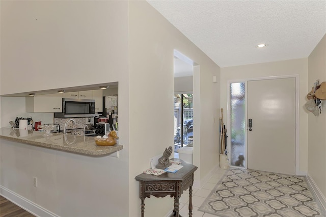 tiled foyer entrance with a textured ceiling