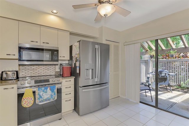 kitchen with appliances with stainless steel finishes, tasteful backsplash, cream cabinetry, ceiling fan, and light tile patterned flooring