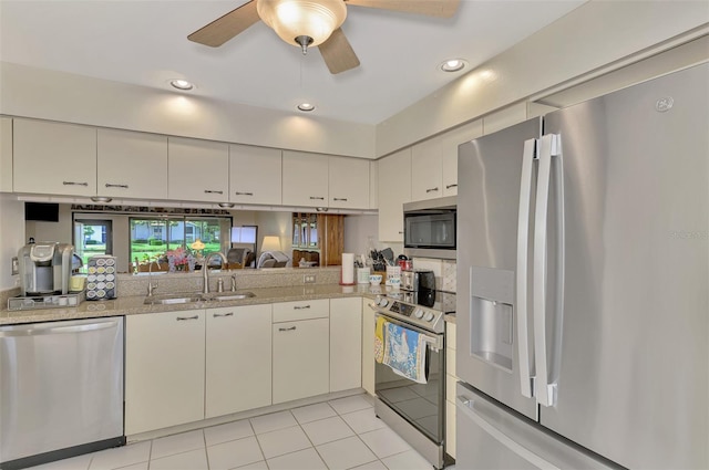 kitchen featuring appliances with stainless steel finishes, light tile patterned floors, sink, and ceiling fan