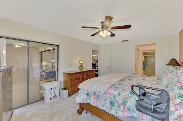 carpeted bedroom with a textured ceiling, ceiling fan, and a closet