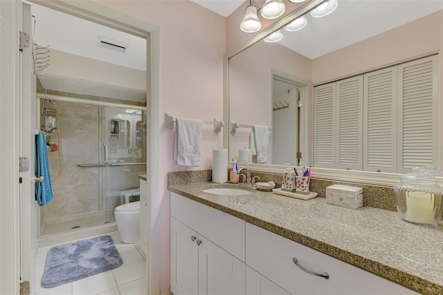 bathroom featuring vanity, toilet, a shower with shower door, and tile patterned floors