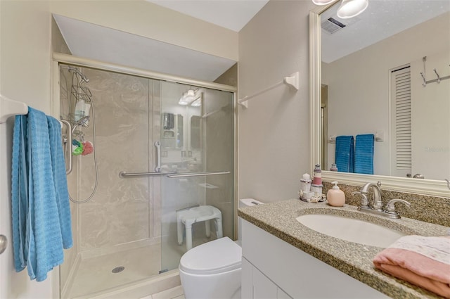 bathroom with vanity, toilet, and a shower with shower door