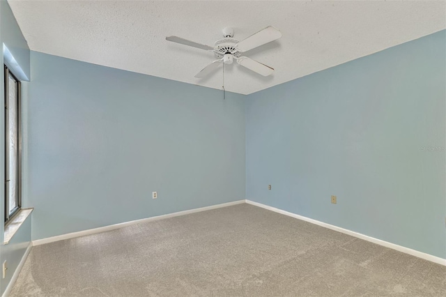 carpeted spare room featuring a textured ceiling and ceiling fan