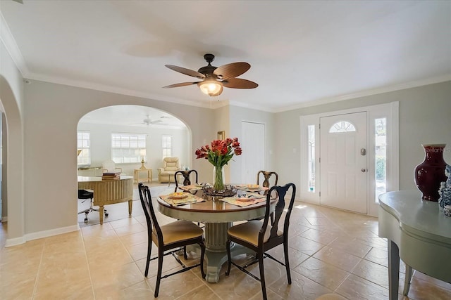 tiled dining area with ornamental molding, a healthy amount of sunlight, and ceiling fan