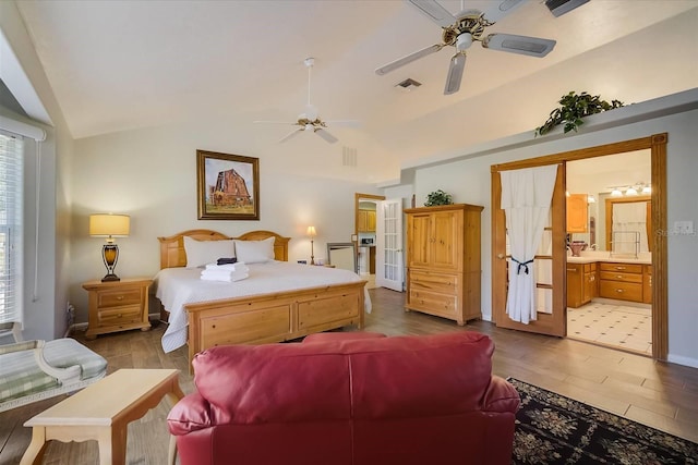 bedroom featuring hardwood / wood-style floors, ceiling fan, ensuite bathroom, and vaulted ceiling