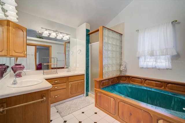 bathroom with vanity, vaulted ceiling, independent shower and bath, and tile patterned floors