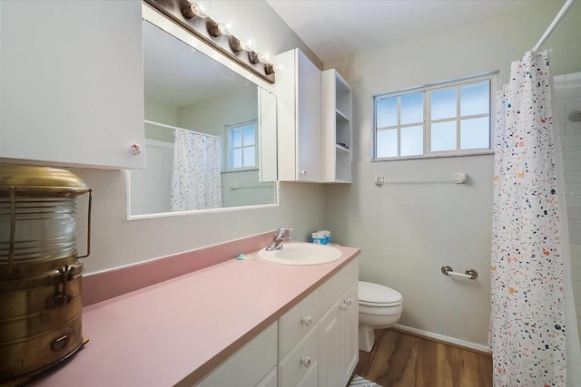 bathroom with vanity, toilet, plenty of natural light, and hardwood / wood-style floors