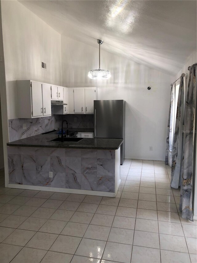 kitchen featuring kitchen peninsula, sink, light tile patterned floors, and white cabinets