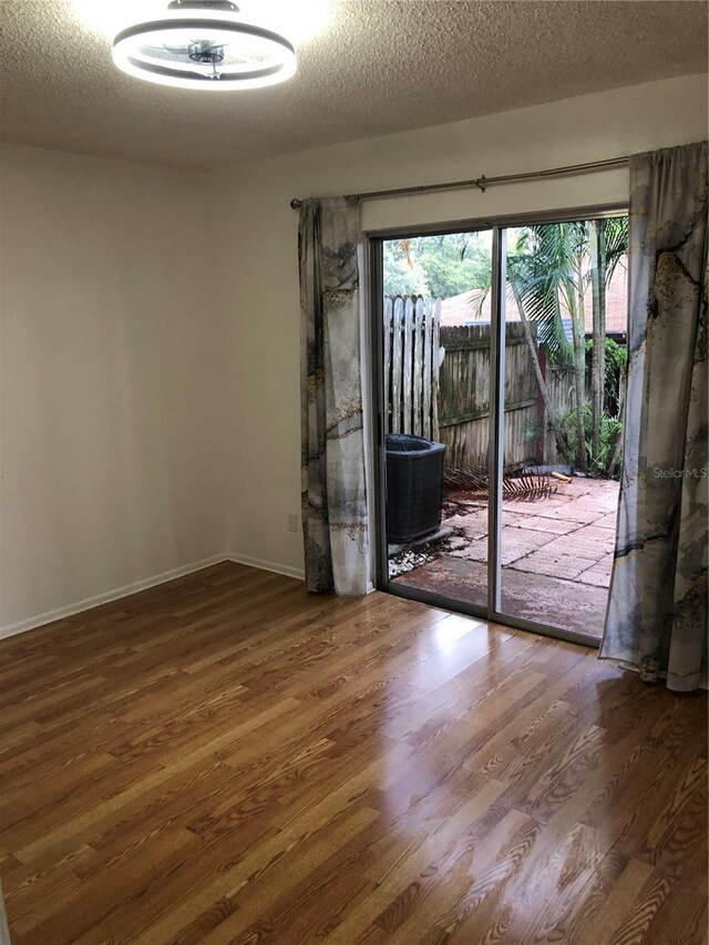 spare room featuring dark hardwood / wood-style flooring and a textured ceiling