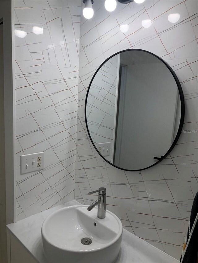 bathroom with tile walls and sink