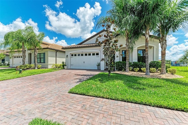 mediterranean / spanish home with a front yard and a garage