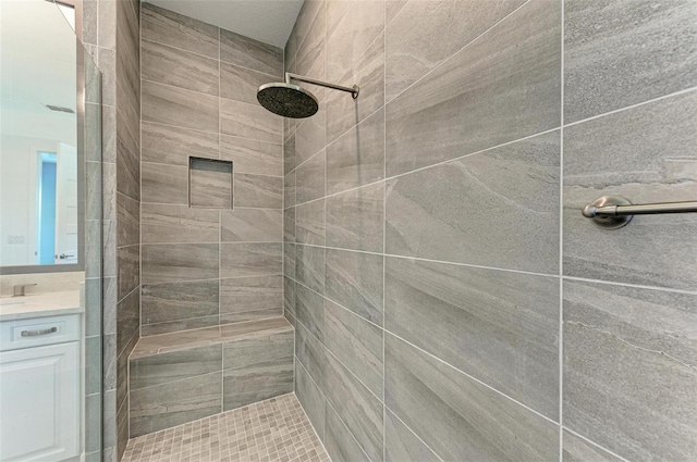 bathroom featuring vanity and a tile shower