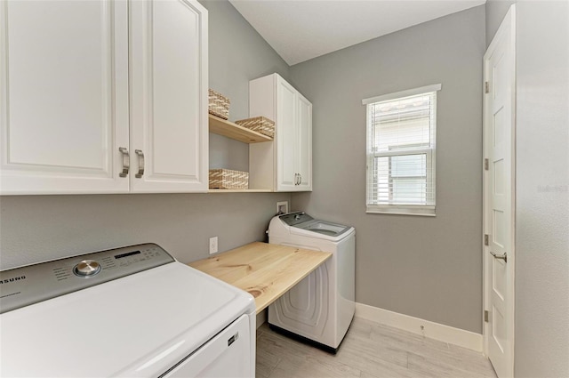 laundry room featuring cabinets, independent washer and dryer, and light wood-type flooring