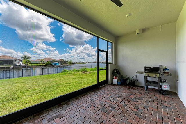 sunroom featuring a water view