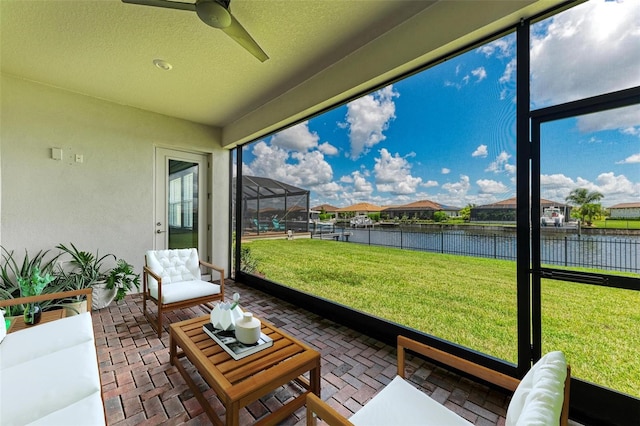 sunroom featuring a water view and ceiling fan