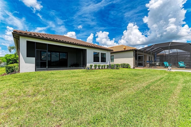 rear view of house featuring a patio area, a swimming pool, a yard, and a lanai