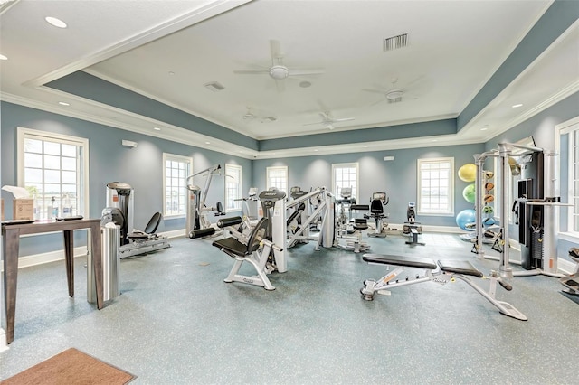 gym featuring a tray ceiling, ceiling fan, and crown molding