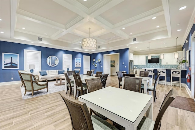 dining space featuring light hardwood / wood-style floors, beamed ceiling, and ornamental molding