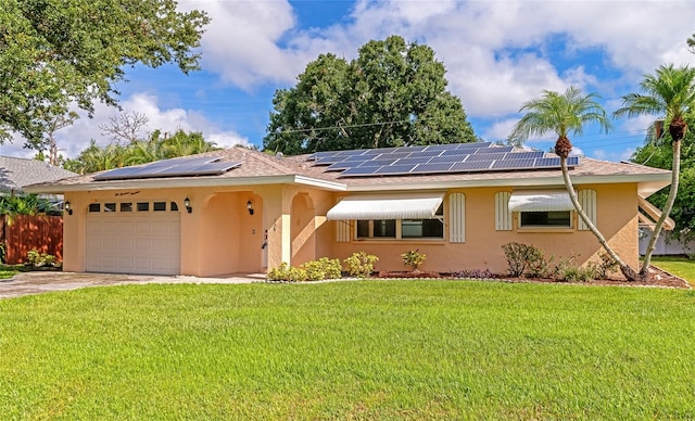 ranch-style home with a front lawn, a garage, and solar panels