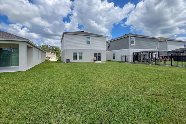 rear view of house featuring cooling unit and a lawn