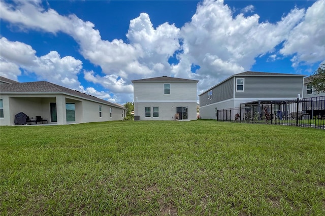 back of property with a yard and a patio area