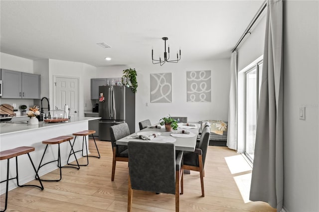 dining area with a chandelier and light hardwood / wood-style floors