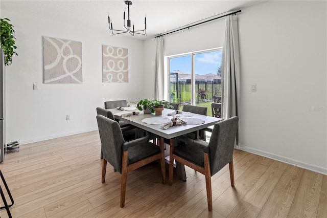 dining room featuring light wood-type flooring and a chandelier