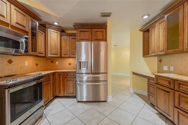 13460 Marquette Blvd, Fort Myers, FL 33905 - kitchen featuring stainless steel appliances, brown cabinetry, visible vents, and light stone counters