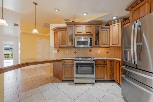 13460 Marquette Blvd, Fort Myers, FL 33905 - kitchen with appliances with stainless steel finishes, brown cabinetry, decorative backsplash, and light tile patterned floors