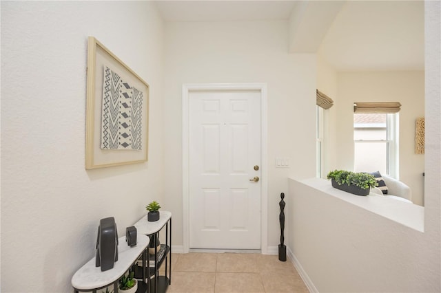 doorway to outside with light tile patterned floors and baseboards