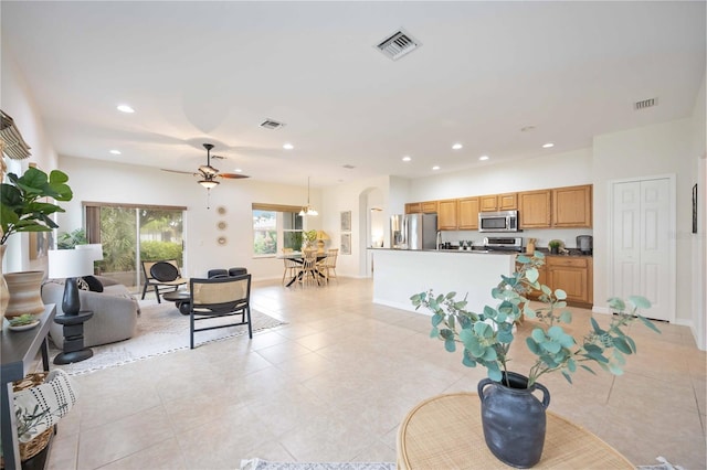 living room with arched walkways, visible vents, and recessed lighting