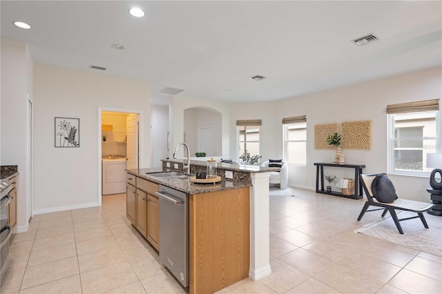 kitchen with stainless steel appliances, washer / clothes dryer, a sink, and visible vents