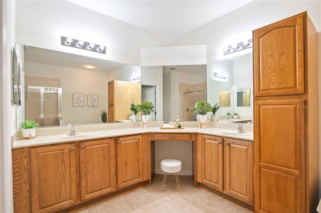 bathroom featuring double vanity, a shower stall, a sink, and tile patterned floors