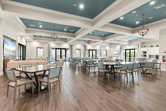 dining space featuring crown molding, beam ceiling, coffered ceiling, and a notable chandelier