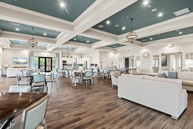 living room with beamed ceiling, crown molding, coffered ceiling, and a notable chandelier