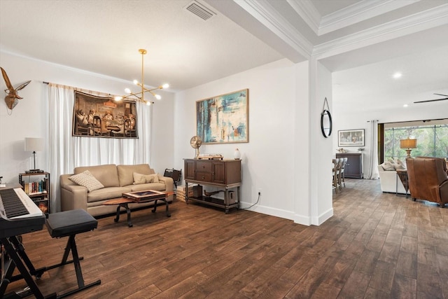 living room featuring ceiling fan with notable chandelier, dark wood-type flooring, and crown molding