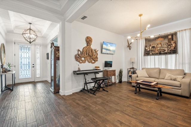 living room featuring dark hardwood / wood-style floors, ornamental molding, and a notable chandelier