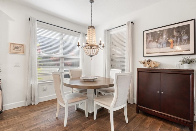 dining space featuring dark hardwood / wood-style flooring and an inviting chandelier