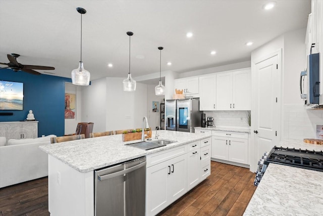 kitchen featuring a center island with sink, appliances with stainless steel finishes, decorative backsplash, white cabinets, and sink