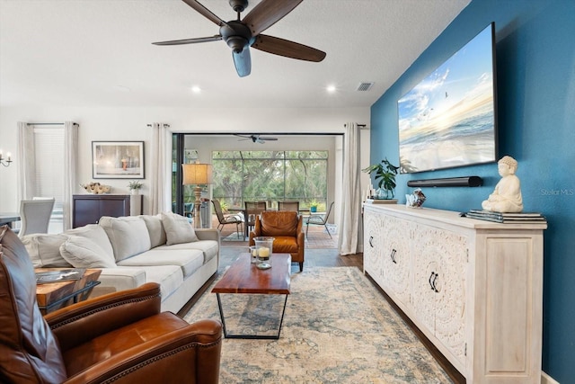 living room featuring ceiling fan and hardwood / wood-style flooring